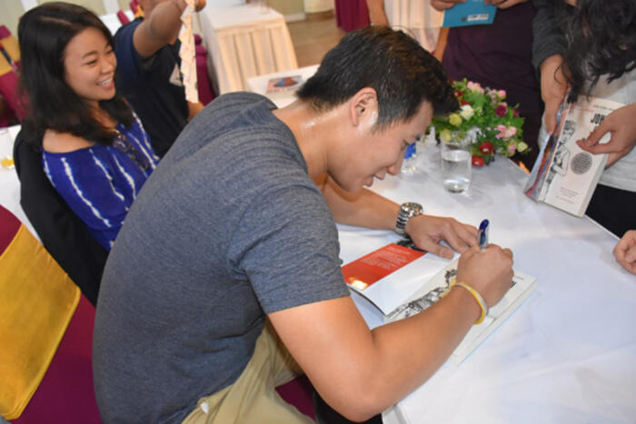 Tác giả John Hùng Trần ký tặng sách cho các bạn trẻ kiều bào