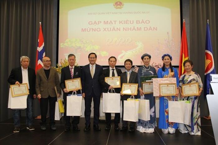 Đại sứ Lê Hồng Lam chụp ảnh cùng kiều bào được khen thưởng.