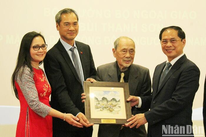 Bộ trưởng Bùi Thanh Sơn tặng quà lưu niệm cho đại diện Hội Người Việt Nam tại Pháp. (Ảnh: Khải Hoàn)