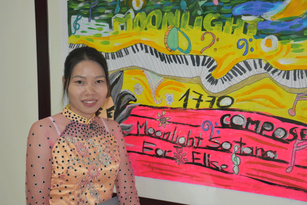 Cô giáo Đoàn Thùy Dương đến từ Lào bên bức tranh do các em tự vẽ