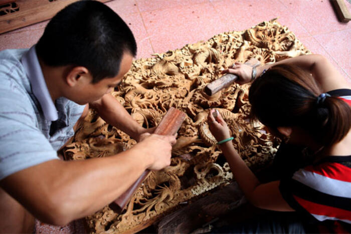 Gia đình thợ chạm trổ Đinh Văn Tuấn - Trần Thị Yến (thôn Phù Khê Thượng, xã Phù Khê) vẫn duy trì nghề chạm trổ rồng trên tranh tường của gia đình để lại