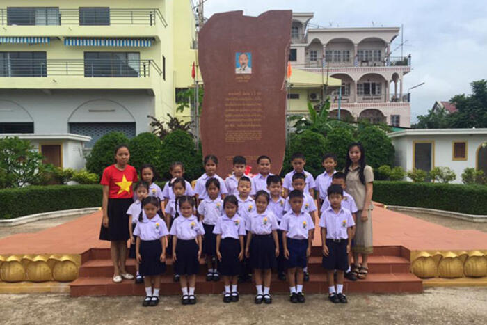 Cô Phương Anh (bên trái) cùng các học sinh trường Hoàng Oanh đến thăm Tượng đài lưu niệm Chủ Tịch Hồ Chí Minh tại Savanakhet