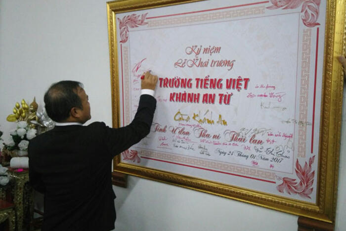 Thứ trưởng Vũ Hồng Nam ký tên lưu niệm lên bảng kỷ niệm Lễ khai trường lớp tiếng Việt