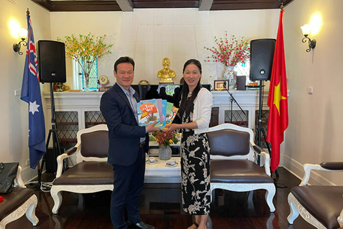 Phó Chủ nhiệm Mai Phan Dũng tặng sách dạy tiếng Việt cho chị Hồng Vân