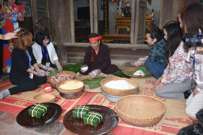 Kiều bào trải nghiệm gói bánh chưng tại làng văn hóa Hùng Lô