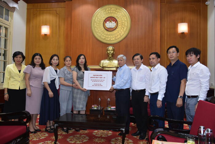 Thứ trưởng Lê Thị Thu Hằng thay mặt chị Phạm Minh Hường - Giám đốc Công ty Sakai – Lào trao 100 triệu đồng cho Chủ tịch Ủy ban TW Mặt trận Tổ quốc Việt Nam Đỗ Văn Chiến để hỗ trợ bào vùng bão lụt