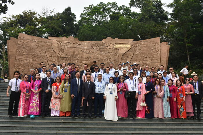 Các đại biểu chụp ảnh lưu niệm tại Bức phù điêu “Bác Hồ nói chuyện với Đại đoàn quân Tiên Phong