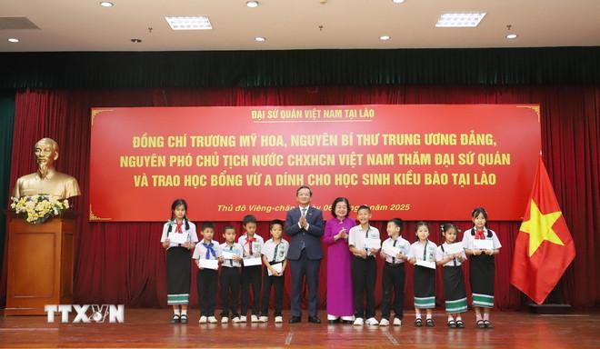 Bà Trương Mỹ Hoa, Chủ tịch Quỹ học bổng Vừ A Dính, Chủ nhiệm Câu lạc bộ “Vì Hoàng Sa-Trường Sa thân yêu” và Đại sứ Việt Nam tại Lào Nguyễn Minh Tâm trao học bổng cho con em kiều bào Việt Nam có thành tích học tập xuất sắc và có hoàn cảnh khó khăn. (Ảnh: Xuân Tú/TTXVN) ttxvn-hoc-bong-vu-a-dinh-tiep-them-dong-luc-hoc-tap-cho-con-em-kieu-bao-tai-lao2.jpg