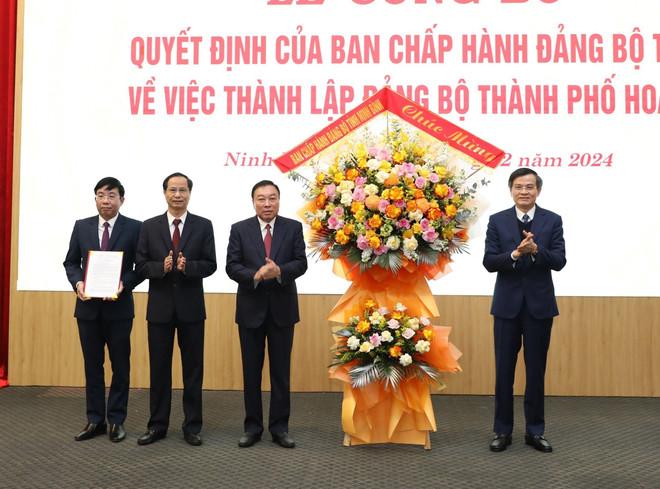 Ông Đoàn Minh Huấn, Ủy viên Trung ương Đảng, Bí thư Tỉnh ủy Ninh Bình trao Quyết định và chúc mừng Đảng bộ thành phố Hoa Lư. (Ảnh: Đức Phương/TTXVN) vna-potal-ninh-binh-cong-bo-quyet-dinh-thanh-lap-dang-bo-thanh-pho-hoa-lu-7776334.jpg