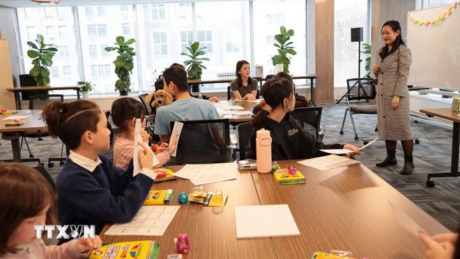 Cô giáo Nguyễn Phương Chung, giảng viên Khoa Ngôn ngữ, Đại học Columbia hướng dẫn học sinh làm quen với tiếng Việt qua trò đố chữ. (Ảnh: Lê Hoàng/TTXVN) ttxvn-lop-day-tieng-viet-cho-tre-em-o-new-york-2-resize.jpg
