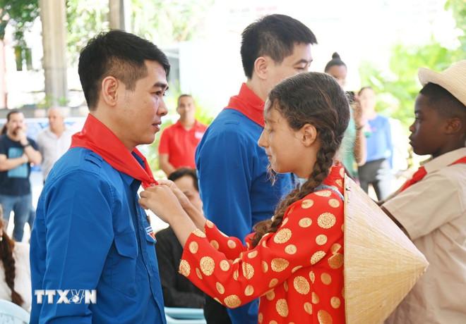 Học sinh trường Tiểu học Võ Thị Thắng quàng khăn đỏ cho cán bộ Trung ương Đoàn Thanh niên Cộng sản Hồ Chí Minh. (Ảnh: Việt Hùng/TTXVN) ttxvn-cuba2.jpg