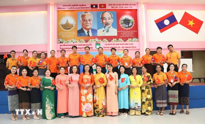 Thầy, cô Việt Nam và Lào ở Trường song ngữ Lào-Việt Nam Nguyễn Du tham dự buổi xem tường thuật trực tiếp Lễ kỷ niệm 50 năm Giải phóng miền Nam, thống nhất đất nước.(Ảnh: Xuân Tú/TTXVN) ttxvn-song-ngu-lao-viet-nguyen-du-3.jpg