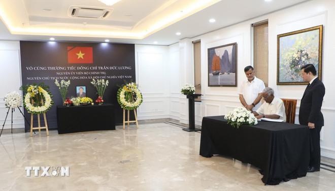 Tổng Bí Thư Đảng Cộng sản Ấn Độ Doraisamy Raja viết sổ tang. (Ảnh: Ngọc Thúy/TTXVN) ttxvn-vieng-nguyen-chu-tich-nuoc-tran-duc-luong-tai-an-do-1.jpg