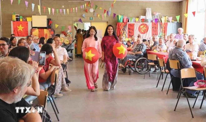 Trình diễn áo dài tại sự kiện. (Ảnh: Hương Giang/TTXVN) ttxvn-hoi-friends-of-vietnamese-kids-tai-thanh-pho-gent-bi-noi-nhung-tam-long-gieo-mam-nhan-ai-8123461.jpg