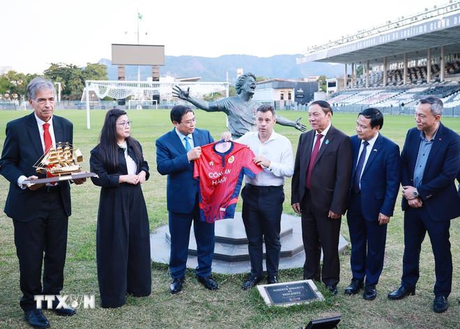 Thủ tướng Phạm Minh Chính tặng áo Câu lạc bộ Công an Hà Nội cho đại diện Câu lạc bộ bóng đá Vasco da Gama. (Ảnh: Dương Giang/TTXVN) ttxvn-thu-tuong-pham-minh-chinh-tham-cau-lac-bo-bong-da-vasco-de-gama-8.jpg