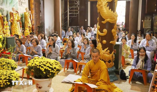 Các Phật tử thực hiện nghi lễ cầu an, tụng kinh, niệm Phật tại buổi lễ. (Ảnh: Xuân Tú/ TTXVN) ttxvn-0807-chua-phat-tich-lao-3.jpg