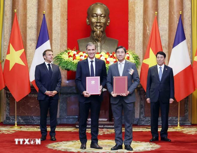 Đại tá Ngô Minh Thuấn, Tổng Giám đốc Tổng công ty Tân Cảng Sài Gòn và Chủ tịch tập đoàn CMA-CGM Rodolphe Saade trao đổi Biên bản thoả thuận hợp tác khai thác dự án Bến 7 và 8 Lạch Huyện, Hải Phòng giữa Tổng công ty Tân Cảng Sài Gòn và Tập đoàn CMA-CGM (CMA Terminals). (Ảnh: Lâm Khánh/TTXVN) ttxvn-macron-hop-tac-kinh-te.jpg