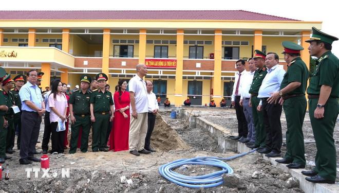 Đoàn công tác của Bộ Quốc phòng nghe báo cáo tiến độ xây dựng phòng học bán trú cho trẻ em biên giới tại Trường Tiểu học xã Bến Cầu, tỉnh Tây Ninh do Bộ Quốc phòng tài trợ. (Ảnh: Minh Phú/TTXVN) ttxvn-quoc-phong-tay-ninh-2.jpg