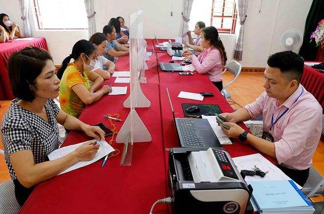 Ngay sau ngày 1/7 mô hình chính quyền địa phương 2 cấp chính thức đi vào hoạt động, Ngân hàng Chính sách xã hội chỉ đạo chi nhánh Ngân hàng Chính sách xã hội các tỉnh, thành phố duy trì thực hiện ngay việc giao dịch giải ngân thuận lợi cho người dân. (Ảnh: Vietnam+) a1-tt-van-quan-7238.jpg