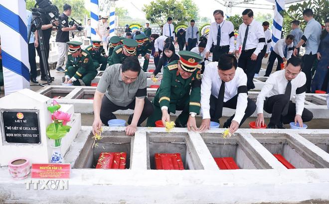 Thủ tướng Phạm Minh Chính thả hoa và đất an táng các liệt sỹ quân tình nguyện, chuyên gia Việt Nam tại Nghĩa trang Liệt sỹ Dốc Bà Đắc (phường Thới Sơn, tỉnh An Giang). (Ảnh: Dương Giang/TTXVN) ttxvn-thu-tuong-pham-minh-chinh-du-le-truy-dieu-an-tang-hai-cot-liet-si-tai-nghia-trang-liet-si-doc-ba-dac-tinh-an-giang-8160699-2.jpg