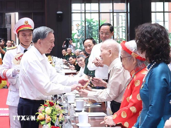 Tổng Bí thư Tô Lâm tặng quà cho cán bộ lão thành cách mạng. (Ảnh: Thống Nhất/TTXVN) ttxvn-tong-bi-thu-to-lam-gap-mat-dai-bieu-co-cong-voi-voi-cach-mang-3107-2.jpg