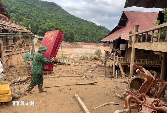 Chiến sỹ Đồn biên phòng Mỹ Lý giúp người dân địa phương khắc phục hậu quả mưa lũ. (Ảnh: TTXVN phát) ttxvn-xa-bien-gioi-my-ly-nghe-an-tan-hoang-sau-mua-lu-8168171-9.jpg