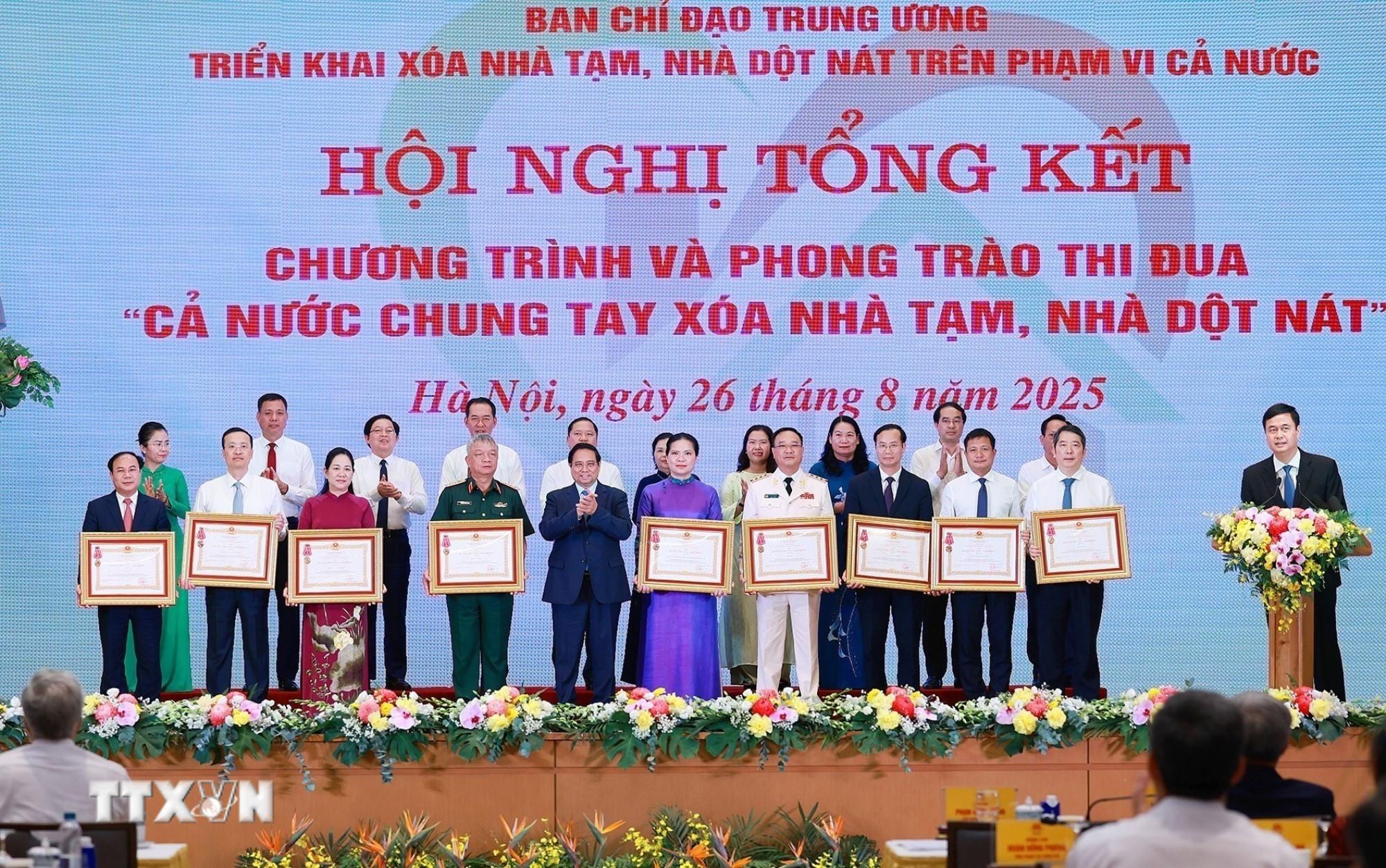 Thủ tướng Phạm Minh Chính trao Huân chương Lao động hạng Ba cho các tập thể có thành tích xuất sắc trong Phong trào thi đua “Cả nước chung tay xóa nhà tạm, nhà dột nát”. (Ảnh: Dương Giang/TTXVN) ttxvn-chung-tay-xoa-nha-tam.jpg