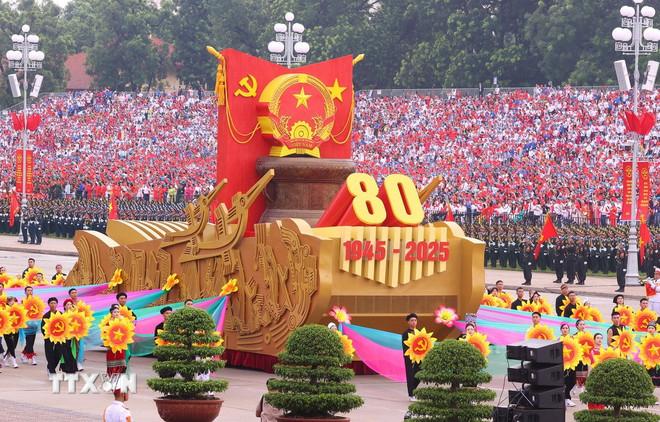 Xe mô hình Quốc huy nước Cộng hòa xã hội chủ nghĩa Việt Nam đi đầu khối diễu binh, diễu hành. (Ảnh: TTXVN) ttxvn-0209-le-dieu-binh-68.jpg