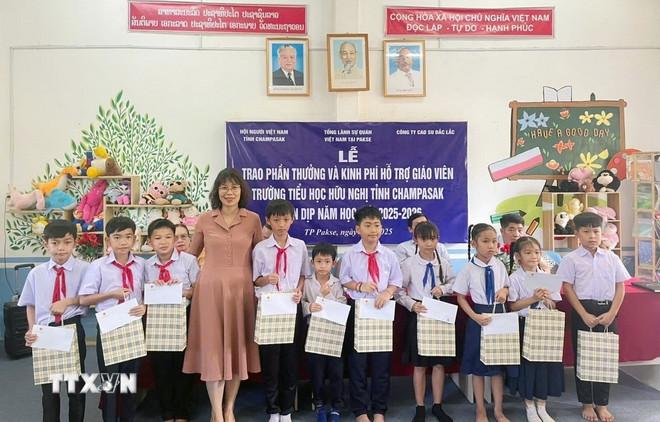 Bà Tạ Phương Dung, Tổng Lãnh sự Việt Nam tại Pakse trao quà và phần thưởng cho học sinh trường Hữu nghị Lào - Việt tỉnh Champasak, Lào nhân dịp năm học mới. (Ảnh: TTXVN phát) ttxvn-gin-giu-ngon-ngu-vun-dap-tinh-huu-nghi-viet-lao2.jpg