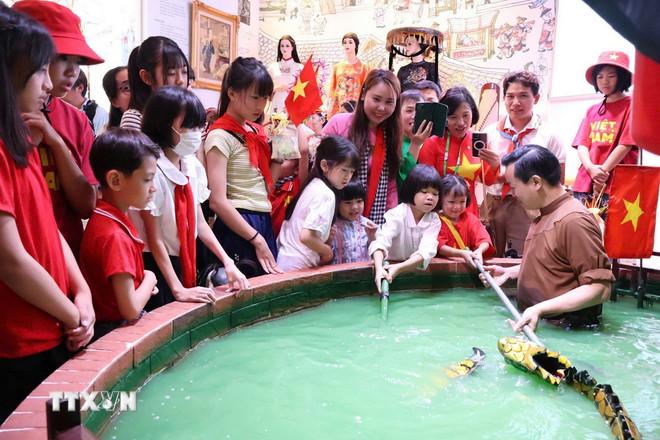 ttxvn-0610-tre-em-viet-nam-nhat-ban-mua-roi-nuoc.jpg