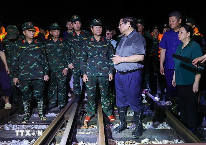 Thủ tướng Phạm Minh Chính kiểm tra tuyến đường sắt bị sạt lở do ảnh hưởng của lũ trên sông Cầu. (Ảnh: Dương Giang/TTXVN) ttxvn-thu-tuong-kiem-tra-chi-dao-ung-pho-lu-tai-khu-vuc-ngoai-thanh-ha-noi8.jpg