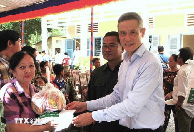 Đại sứ Việt Nam tại Campuchia Nguyễn Minh Vũ và Phó Tỉnh trưởng tỉnh Takeo Soth Khun trao tặng quà cho người dân tham gia chương trình. (Ảnh: Hoàng Minh/TTXVN) ttxvn-campuchia-1.jpg
