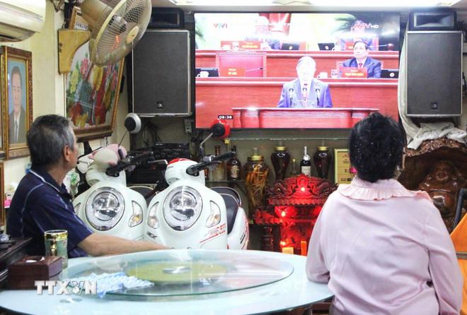 Gia đình ông Đinh Văn Kiện, người gốc Việt ở phường Chak Angre Krom (quận Mean Chey, thủ đô Phnom Penh, Campuchia) cùng gia đình theo dõi truyền hình trực tiếp Lễ khai mạc Đại hội XIV của Đảng. (Ảnh: Hoàng Minh/TTXVN) ttxvn-dinh-van-kien-resize.jpg