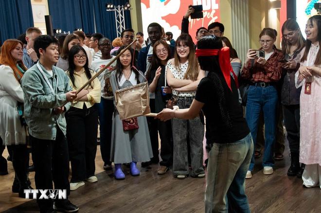 Các bạn trẻ Ấn Độ, Indonesia và Nga tìm hiểu trò chơi đập niêu. (Ảnh: Trần Hải/TTXVN) ttxvn-van-hoa-viet-nam-toa-sang-tai-tomsk-viet-nam-con-nguoi-va-to-quoc3.jpg