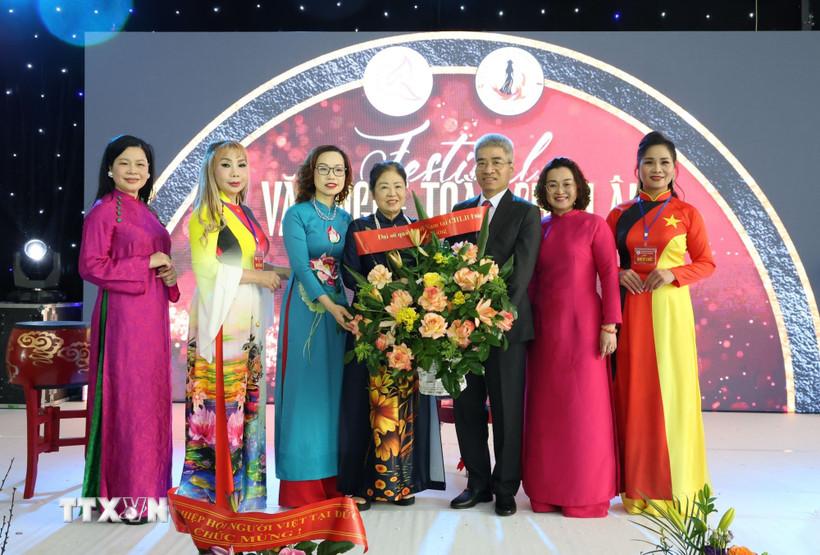 Đại sứ Nguyễn Đắc Thành và Phu nhân tặng hoa cho bà Trịnh Thị Mùi, Chủ tịch Hội Nữ Doanh nhân Việt Nam tại châu Âu. (Ảnh: Thu Hằng/TTXVN)